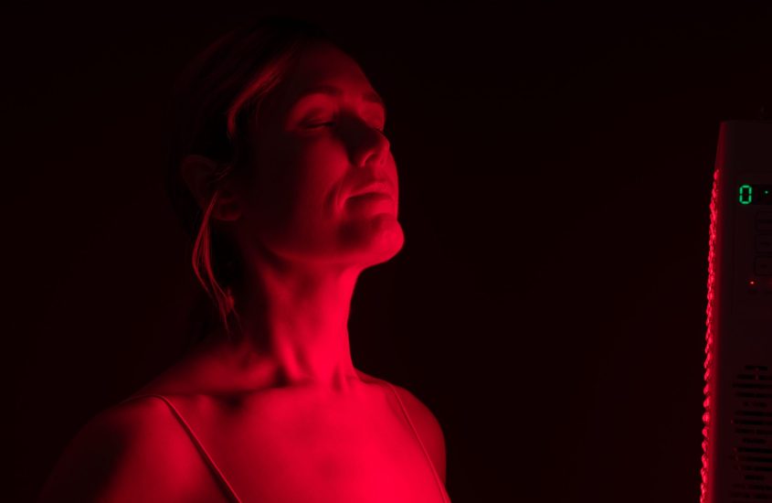 Woman getting red light therapy from a red light device