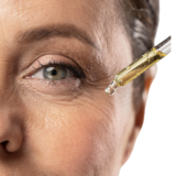Picture shows the eye of a mature lady with serum being applied.