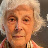 A close-up photo of my mum Rhoda alongside a purple bottle of Elevator serum from Trinny London
