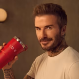 David Beckam pictured holding a cup with his IM8 Daily Essentials drink