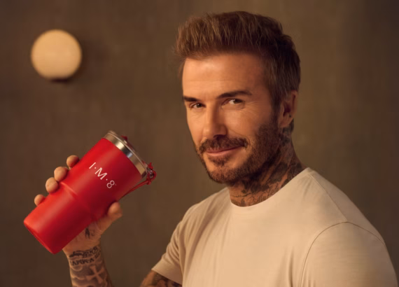David Beckam pictured holding a cup with his IM8 Daily Essentials drink